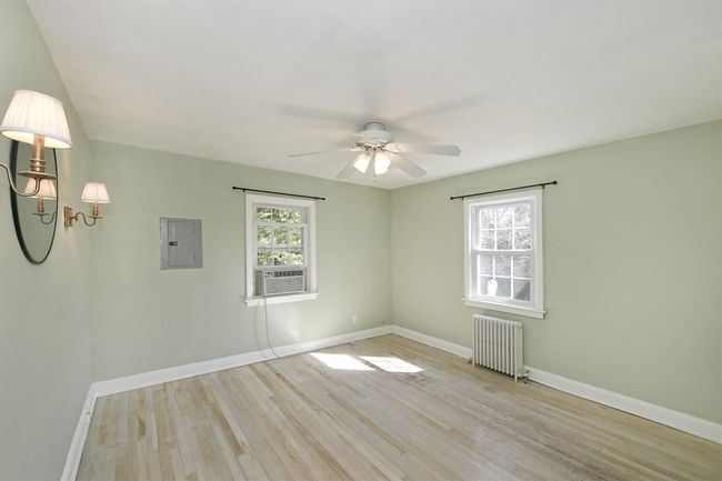 Spare room with electric panel, plenty of natural light, light wood-style flooring, and radiator heating unit | Image 13