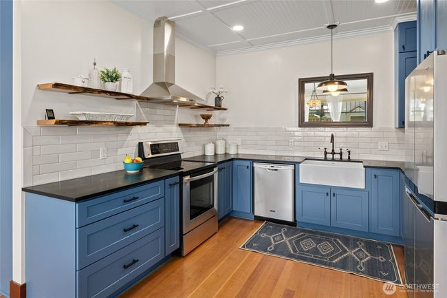 The kitchen features all-new cabinetry, sleek countertops, and stainless steel appliances—offering a fresh, modern look with everyday functionality. | Image 12