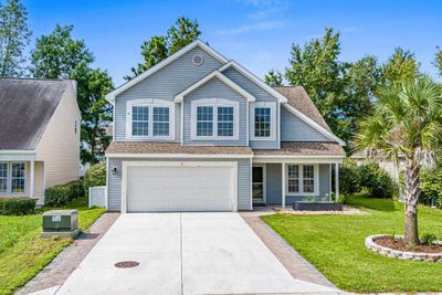 View of front facade with a front yard and a garage | Image 1