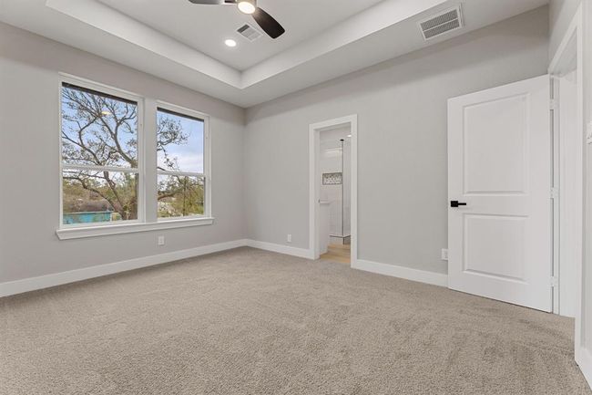 Primary bedroom offers plenty of natural lighting and high ceilings for a soothing retreat from the work week. | Image 20