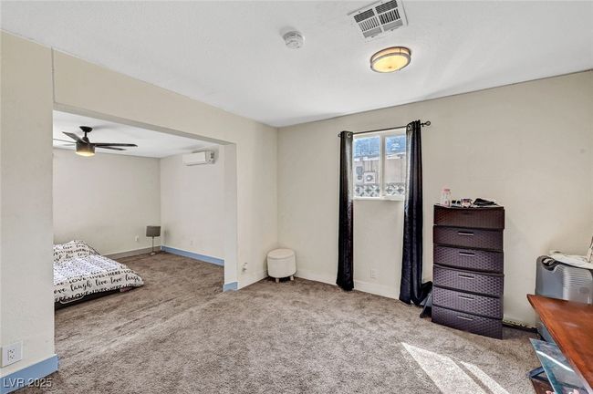 Carpeted bedroom featuring a wall unit AC and baseboards | Image 24