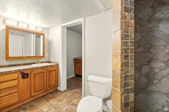 Bathroom featuring vanity and a textured ceiling | Image 38