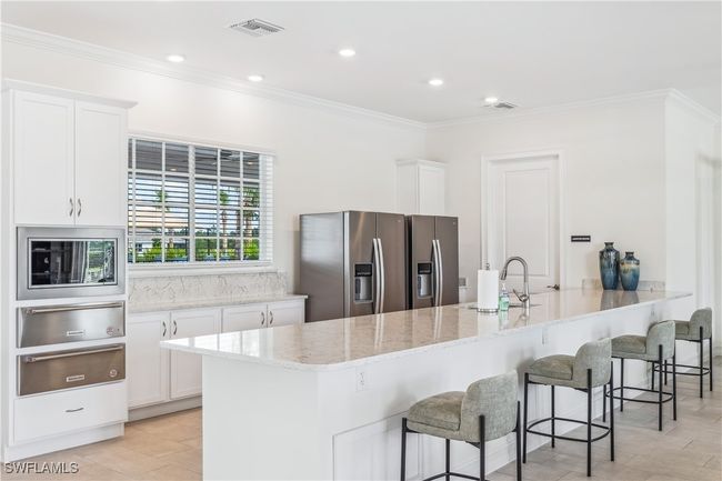 Kitchen featuring white cabinets, stainless steel appliances, sink, and a kitchen breakfast​​‌​​​​‌​​‌‌​‌‌​​​‌‌​​‌‌​‌​​​​​‌ bar | Image 7