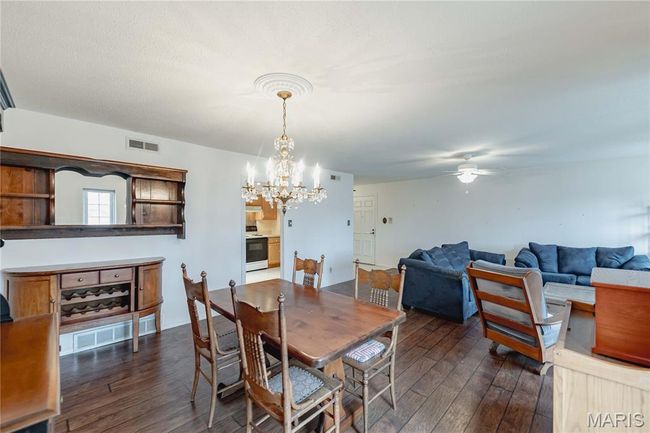 Dining space featuring dark wood-style floors, a ceiling fan, and a chandelier | Image 17