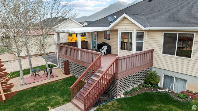 Wooden terrace featuring a patio, a mountain view, and a lawn | Image 38