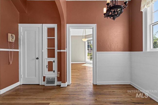 Spare room featuring wood finished floors, a chandelier, and arched walkways | Image 18