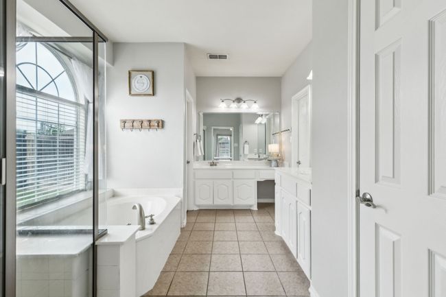 Primary ensuite bathroom with a garden tub, tile flooring, separate shower, and two vanities | Image 19