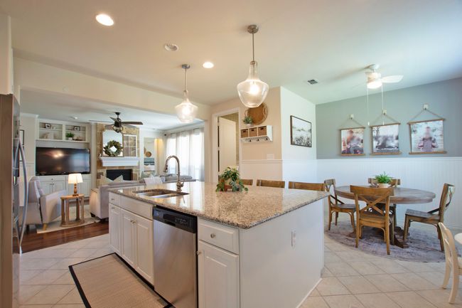 Kitchen with a sink, open floor plan, a ceiling fan, light tile patterned floors, and stainless steel appliances | Image 12