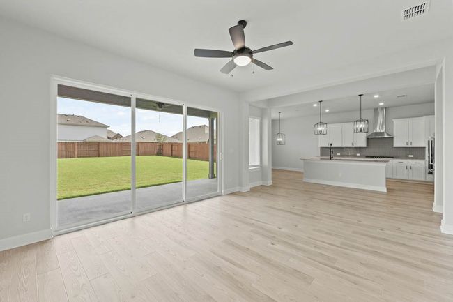 The large family room is located at the heart of the home offering the ideal space for gathering with friends and family. Large windows along the back of the home offer views of the covered outdoor living area and your large back yard. | Image 9