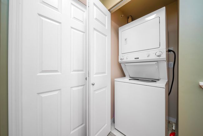 Laundry room with stacked washer and dryer, baseboards, and laundry area | Image 34