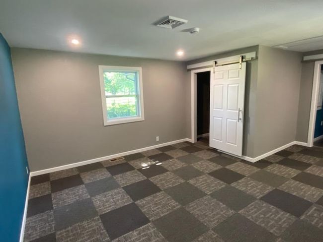 Unfurnished bedroom featuring a barn door | Image 21