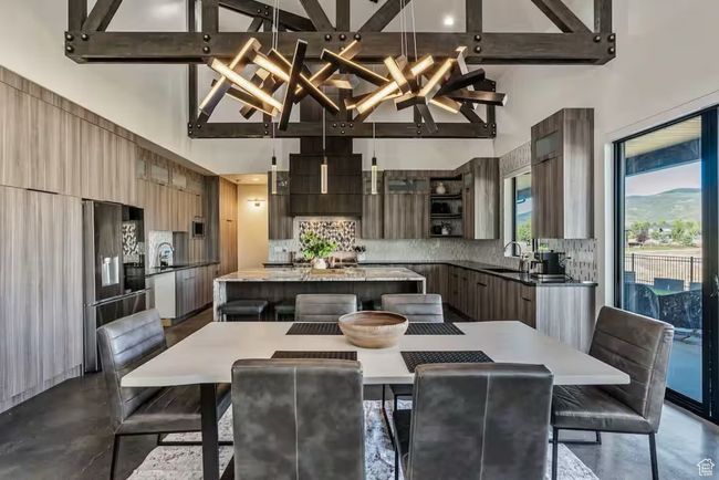 Dining room with high vaulted ceiling, concrete flooring, and beam ceiling | Image 7