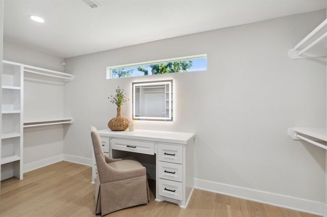 A built-in vanity is thoughtfully tucked into the generous walk-in closet. | Image 21