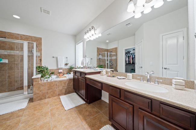 Full bathroom featuring vanity, a shower stall, a garden tub, tile patterned floors, and a walk in closet | Image 15