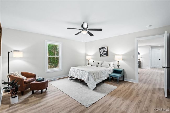 Spacious bedroom with walk in closet, luxury vinyl woodgrain flooring and ceiling fan | Image 15
