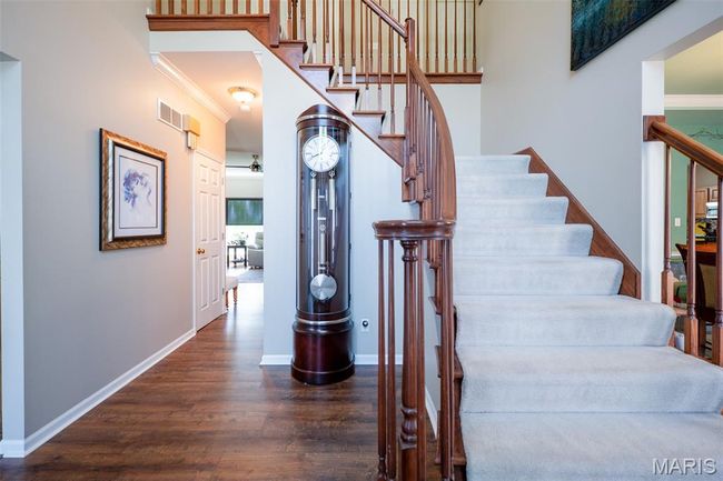 Staircase featuring wood finished floors and ornamental molding | Image 23