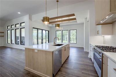 Kitchen with an island with sink, sink, dark hardwood / wood-style floors, appliances with stainless steel finishes, and extractor fan | Image 2