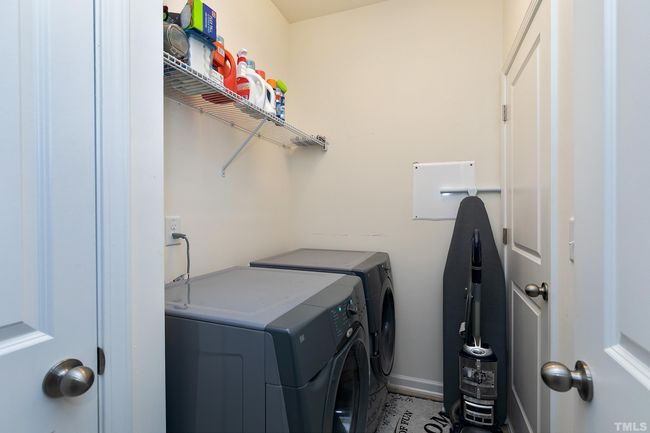 The laundry room is sizable with a shelf over the washer and dryer. There is a broom closet in this room also. | Image 32