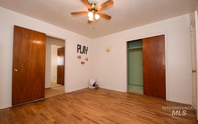 Unfurnished bedroom with wood finished floors, a closet, and ceiling fan | Image 24