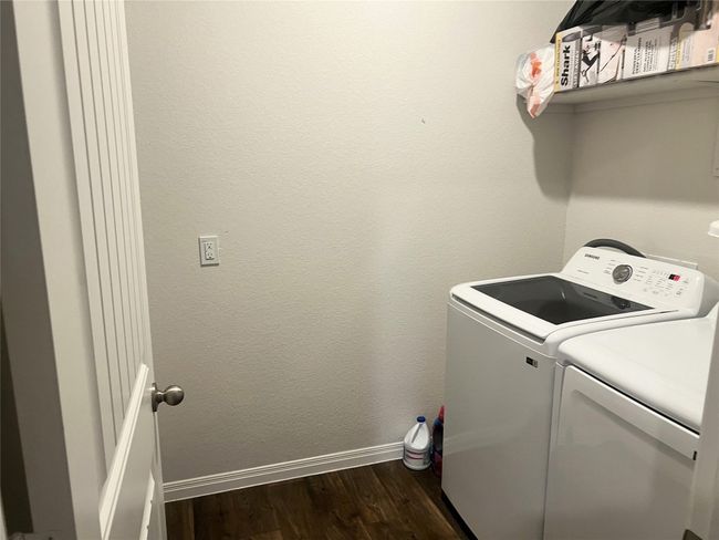 Laundry area featuring baseboards, dark wood finished floors, and washer and clothes dryer | Image 20