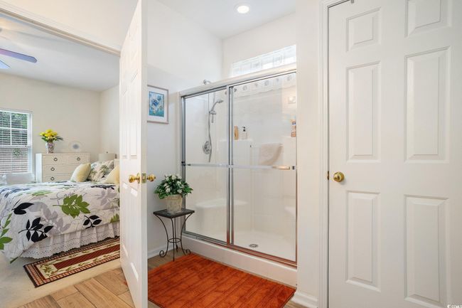 Ensuite bathroom featuring healthy amount of natural light, a stall shower, wood finished floors, ceiling fan, and recessed lighting | Image 22