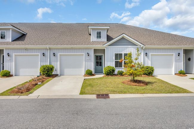 Townhome / multi-family property featuring driveway, a front yard, roof with shingles, and board and batten siding | Image 21
