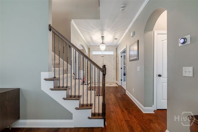 Beautiful staircase between the dining room and the living room leads to four bedrooms and a bonus area up. | Image 5