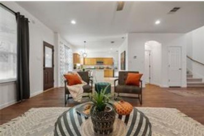 Living room with baseboards, wood finished floors, a healthy amount of sunlight, and arched walkways | Image 18