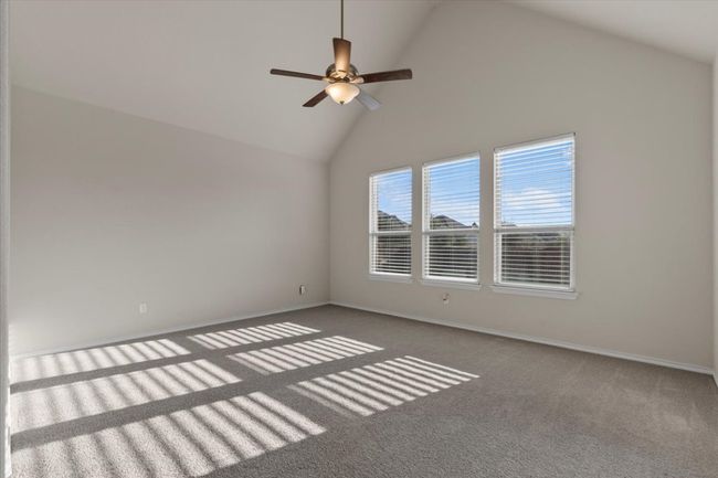 Empty room featuring high vaulted ceiling, ceiling fan, and carpet floors | Image 10