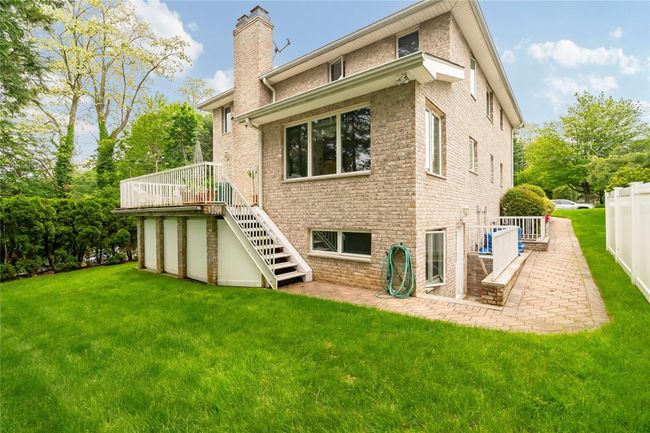 Back of house featuring stairs, a chimney, a wooden deck, and a patio area | Image 49