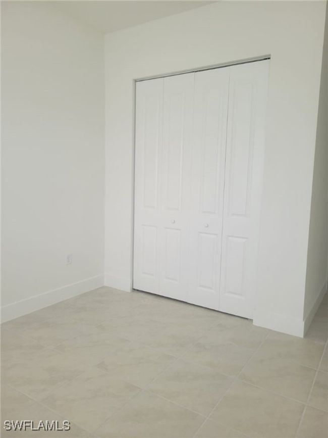 Unfurnished bedroom featuring baseboards, a closet, and light tile patterned flooring | Image 19