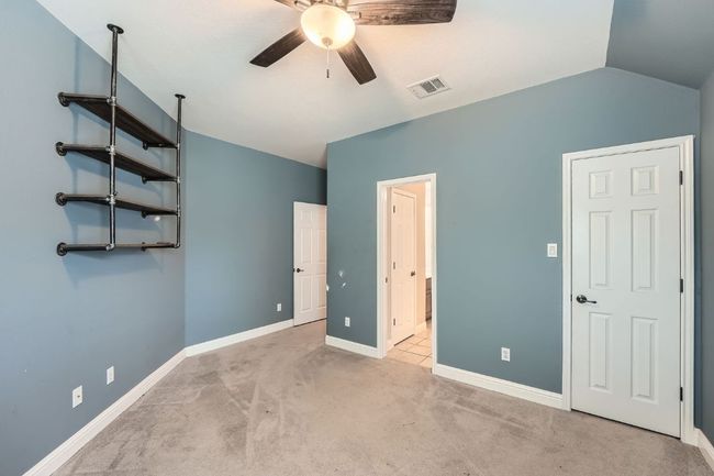 Unfurnished bedroom featuring visible vents, baseboards, a ceiling fan, carpet, and vaulted ceiling | Image 25
