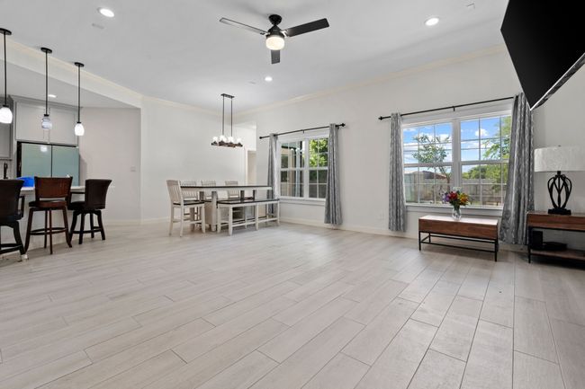 Living area featuring ceiling fan, ornamental molding, recessed lighting, light wood-style floors, and a chandelier | Image 6