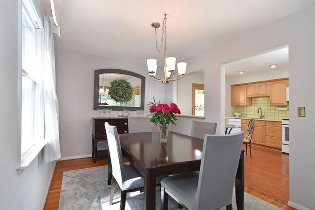 Dining area with a notable chandelier and light wood-style flooring | Image 4