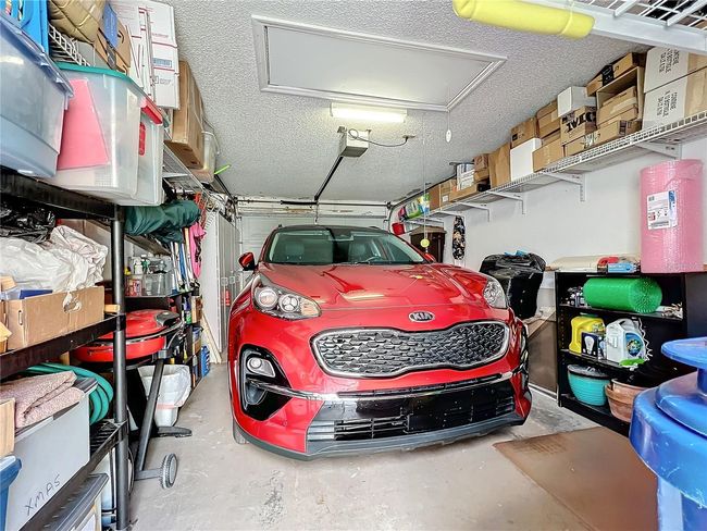 One car garage includes lots of storage, plus pull down stairs and access to large attic storage | Image 41