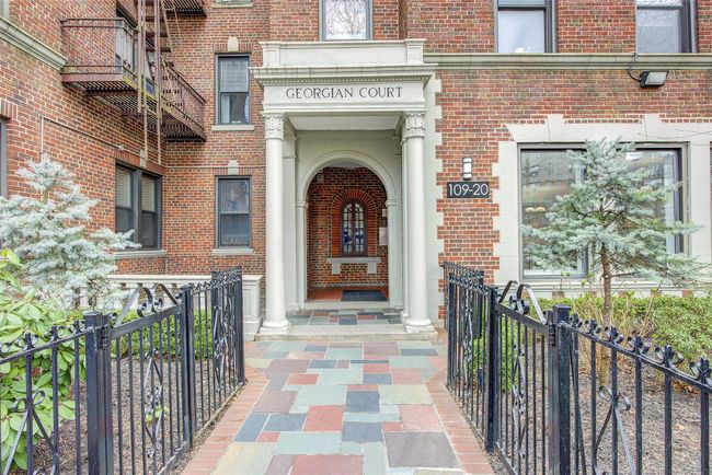 View of exterior entry with brick siding and fence | Image 16