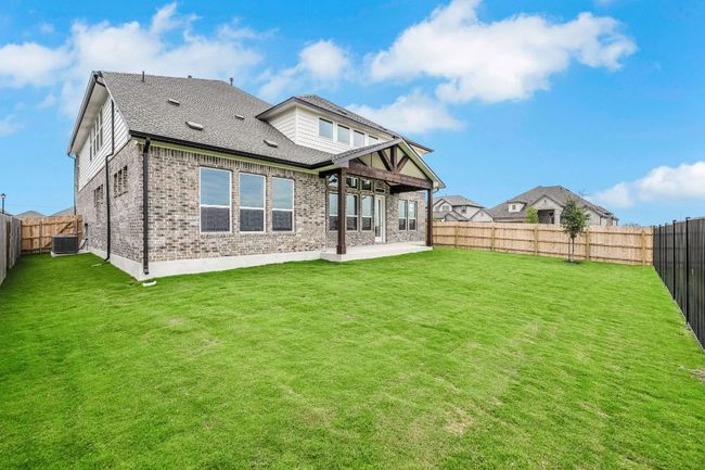 Back of house featuring brick siding, a patio, roof with shingles, and a fenced backyard | Image 26