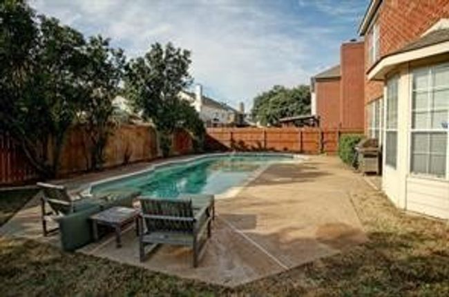 View of swimming pool with a fenced backyard and a patio | Image 18
