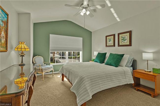 Carpeted bedroom featuring ceiling fan and lofted ceiling | Image 11