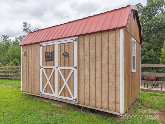 Storage building. The lot behind has a couple of horses which adds to the "fun" of this home! | Image 24