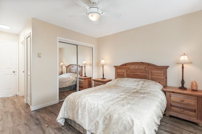 Bedroom with wood finished floors, ceiling fan, a closet, and baseboards | Image 19