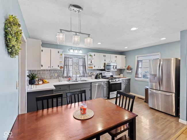 dining space featuring baseboards, a textured ceiling, recessed lighting, and light wood finished floors | Image 12