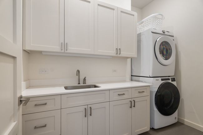 Laundry room with stacked washer and clothes dryer and cabinet space | Image 27