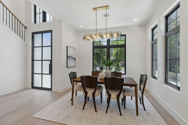 Dining room with wood finished floors, a chandelier, baseboards, and recessed lighting | Image 5