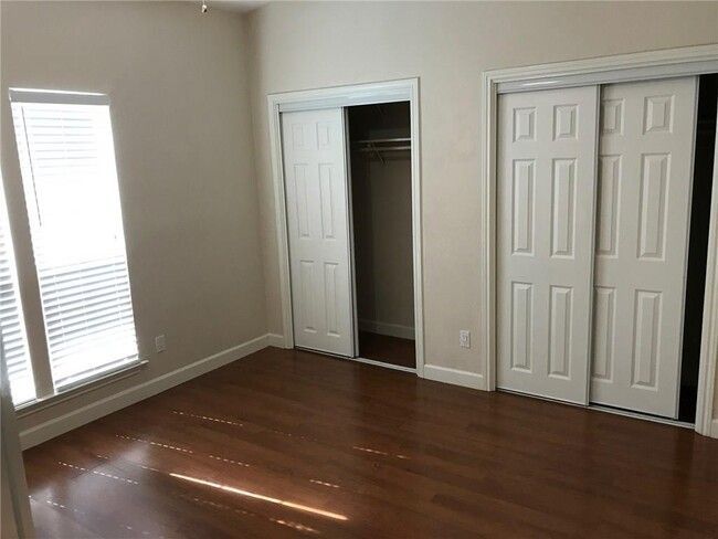 Unfurnished bedroom with baseboards, two closets, and wood finished floors | Image 4