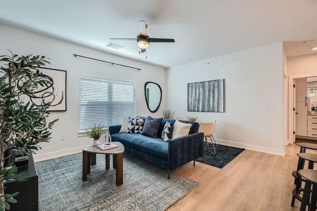 Living area featuring a ceiling fan and light wood-type flooring | Image 7