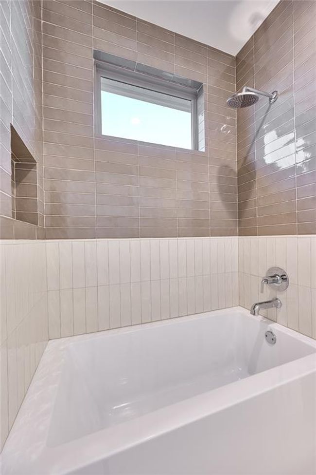The Jack and Jill bathroom features a stylish shower/tub combo, with artisan oyster ceramic tile and rich chestnut ceramic tile adorning the shower. | Image 42