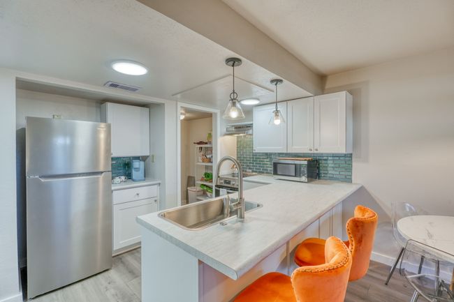 Kitchen lower unit with visible vents, a peninsula, a sink, and stainless steel appliances | Image 4