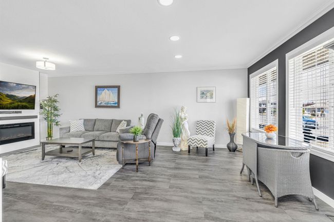 Living area with wood finished floors, baseboards, ornamental molding, and recessed lighting | Image 4