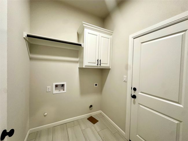 Washroom featuring electric dryer hookup, hookup for a washing machine, gas dryer hookup, baseboards, and cabinet space | Image 23